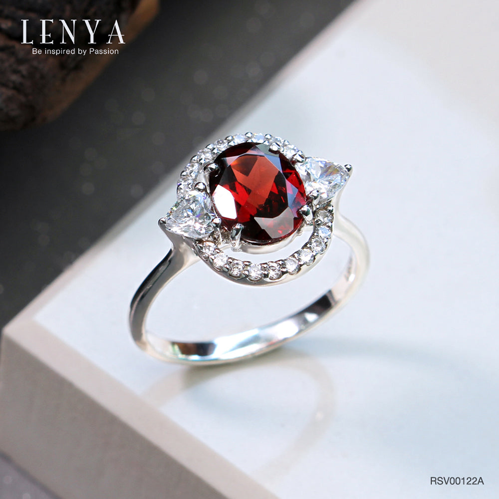 LENYA แหวนโกเมน (Garnet)  สีแดงแก่ก่ำ ช่วยปกป้องคุ้มครอง และช่วยให้สมปรารถนาในเรื่องหน้าที่การงาน การเงินและเรื่องความรัก ล้อมรอบด้วยคิวบิคเซอร์โคเนีย 22 เม็ด บนตัวเรือนเงินแท้ 925 ชุบทองคำขาว