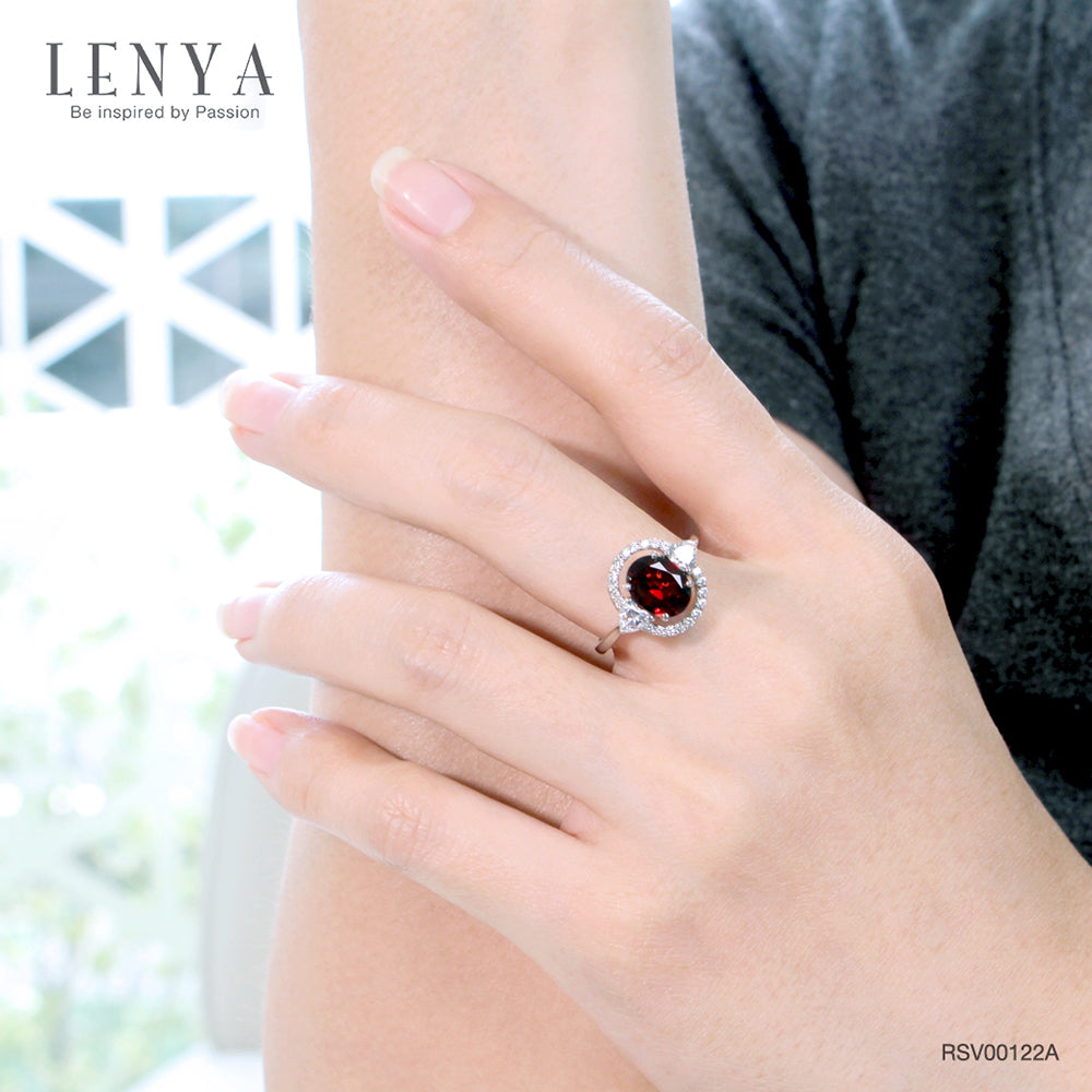 LENYA แหวนโกเมน (Garnet)  สีแดงแก่ก่ำ ช่วยปกป้องคุ้มครอง และช่วยให้สมปรารถนาในเรื่องหน้าที่การงาน การเงินและเรื่องความรัก ล้อมรอบด้วยคิวบิคเซอร์โคเนีย 22 เม็ด บนตัวเรือนเงินแท้ 925 ชุบทองคำขาว