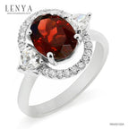 LENYA แหวนโกเมน (Garnet)  สีแดงแก่ก่ำ ช่วยปกป้องคุ้มครอง และช่วยให้สมปรารถนาในเรื่องหน้าที่การงาน การเงินและเรื่องความรัก ล้อมรอบด้วยคิวบิคเซอร์โคเนีย 22 เม็ด บนตัวเรือนเงินแท้ 925 ชุบทองคำขาว