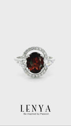 LENYA แหวนโกเมน (Garnet)  สีแดงแก่ก่ำ ช่วยปกป้องคุ้มครอง และช่วยให้สมปรารถนาในเรื่องหน้าที่การงาน การเงินและเรื่องความรัก ล้อมรอบด้วยคิวบิคเซอร์โคเนีย 22 เม็ด บนตัวเรือนเงินแท้ 925 ชุบทองคำขาว